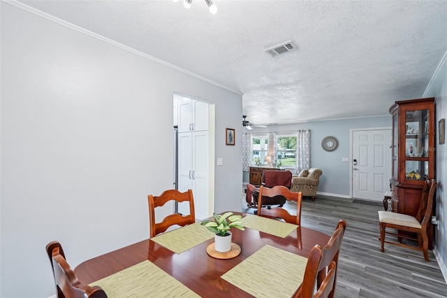 6448 SW 111th Pl, Ocala, FL 34476 - dining area featuring wood finished floors, crown molding, a textured ceiling, and baseboards