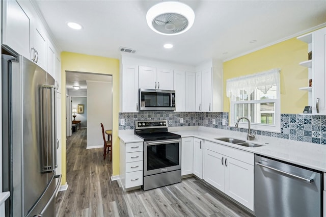 6448 SW 111th Pl, Ocala, FL 34476 - kitchen featuring appliances with stainless steel finishes, a sink, open shelves, light countertops, and white cabinetry