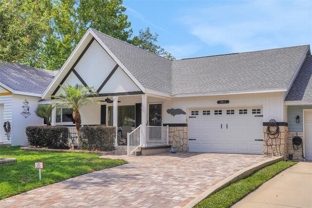 8785 SW 93rd Ln Unit C, Ocala, FL 34481 - view of front facade with an attached garage, a shingled roof, decorative driveway, stone siding, and covered porch