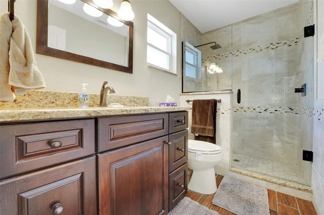 8785 SW 93rd Ln Unit C, Ocala, FL 34481 - bathroom with toilet, vanity, a shower stall, and wood finished floors