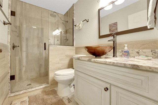 8785 SW 93rd Ln Unit C, Ocala, FL 34481 - bathroom featuring toilet, a stall shower, vanity, and tile walls