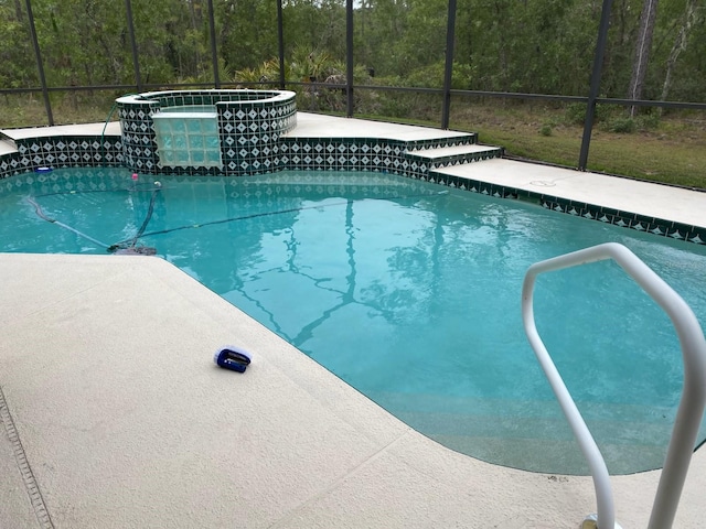 4710 W Mustang Blvd, Beverly Hills, FL 34465 - view of pool featuring a lanai, a view of trees, and a pool with connected hot tub