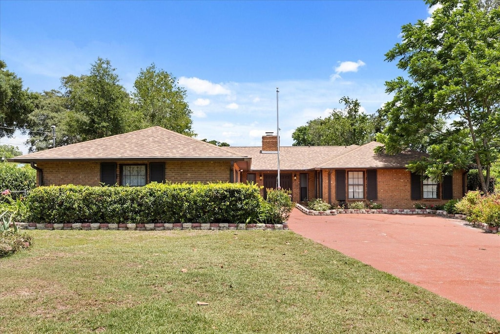 6157 NE 25th Ave, Ocala, FL 34479 - ranch-style home featuring a front yard, brick siding, a chimney, and roof with shingles