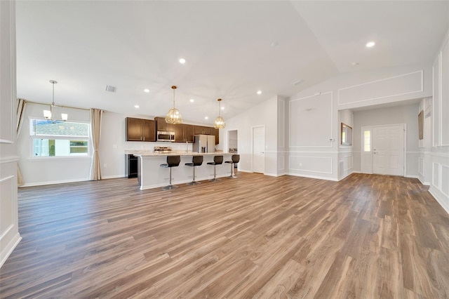 8943 SE 41st Court Rd, Ocala, FL 34480 - unfurnished living room featuring healthy amount of natural light, light wood-style floors, lofted ceiling, a decorative wall, and recessed lighting