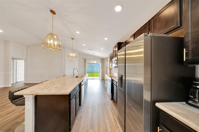 8943 SE 41st Court Rd, Ocala, FL 34480 - kitchen featuring stainless steel appliances, light wood-type flooring, dark brown cabinets, lofted ceiling, and a kitchen island with sink
