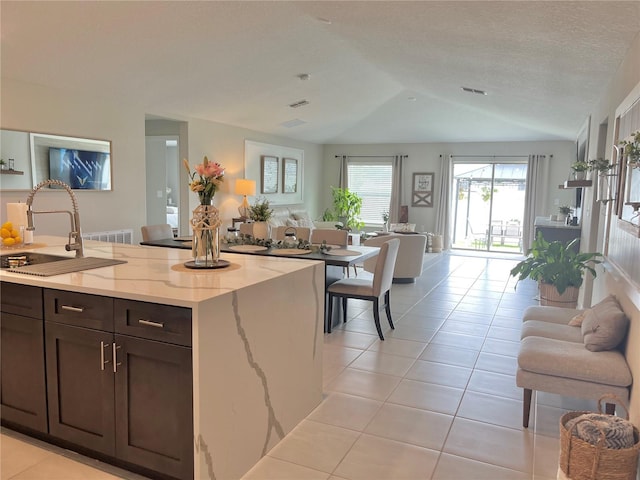 5667 SW 92nd Pl, Ocala, FL 34476 - kitchen featuring open floor plan, light tile patterned flooring, light stone countertops, a sink, and dark brown cabinets