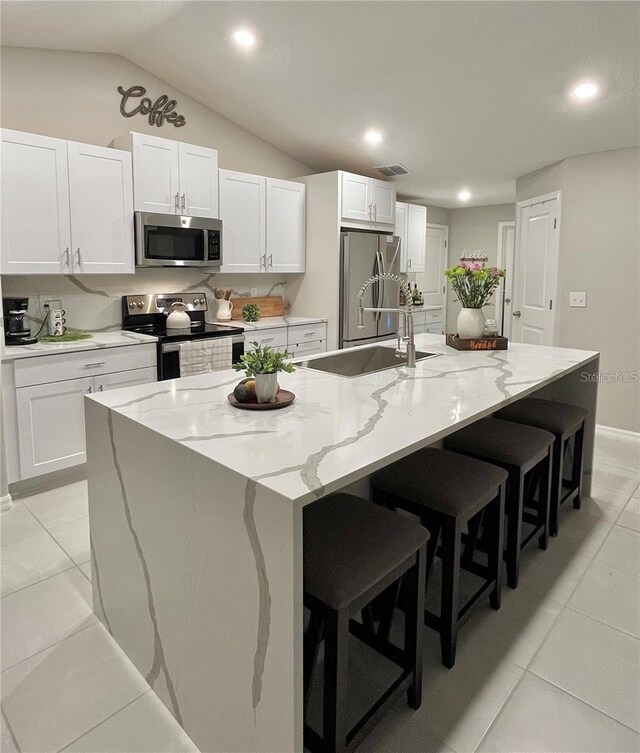 5667 SW 92nd Pl, Ocala, FL 34476 - kitchen featuring appliances with stainless steel finishes, a sink, white cabinetry, vaulted ceiling, and recessed lighting