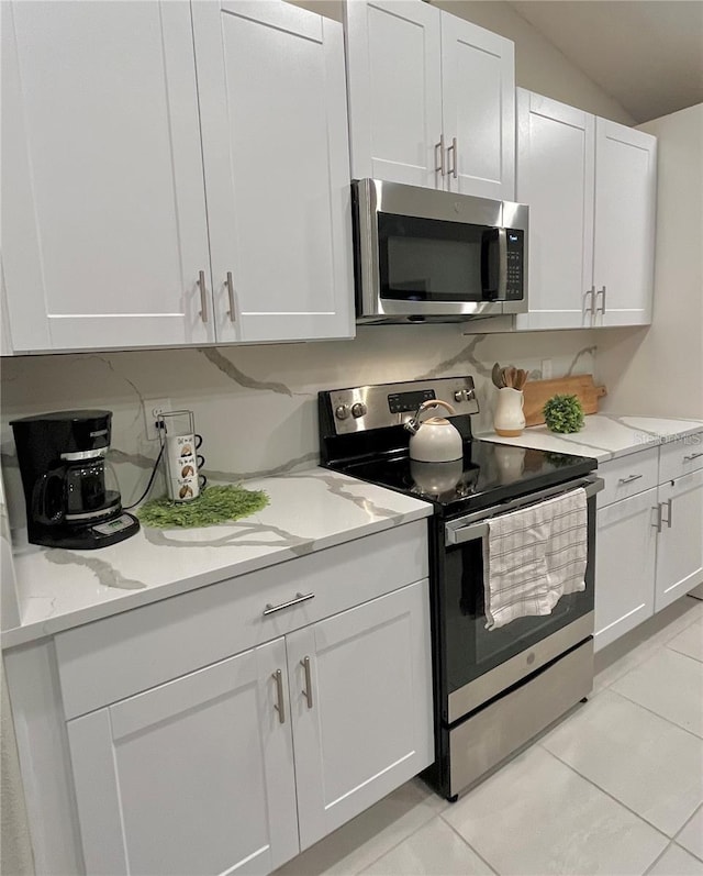 5667 SW 92nd Pl, Ocala, FL 34476 - kitchen featuring stainless steel appliances, white cabinets, light tile patterned floors, and light stone countertops