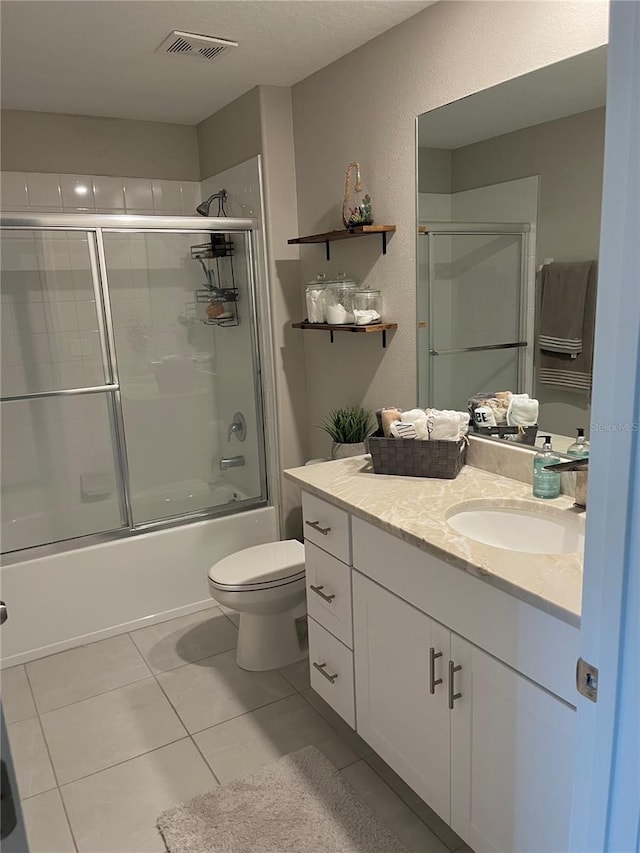 5667 SW 92nd Pl, Ocala, FL 34476 - bathroom with vanity, toilet, combined bath / shower with glass door, tile patterned flooring, and a textured wall