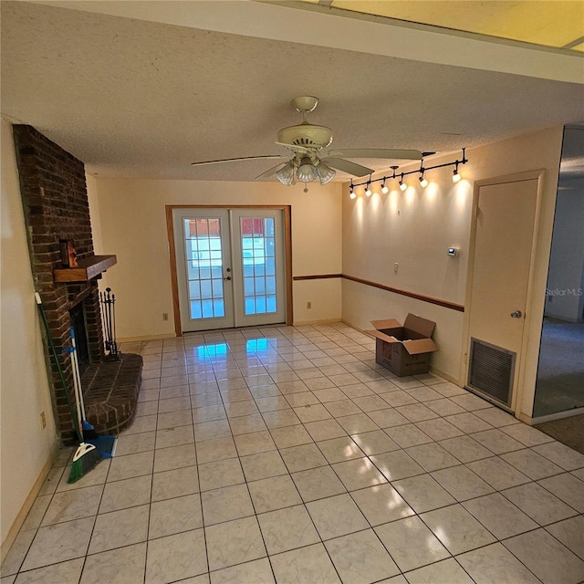 8635 SW 95th St Unit G, Ocala, FL 34481 - unfurnished living room with a fireplace, light tile patterned flooring, a ceiling fan, a textured ceiling, and rail lighting