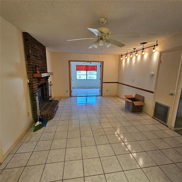 8635 SW 95th St Unit G, Ocala, FL 34481 - unfurnished living room with a textured ceiling, a fireplace, ceiling fan, light tile patterned floors, and baseboards