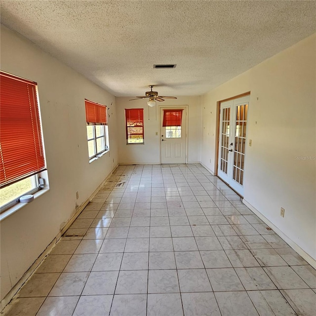 8635 SW 95th St Unit G, Ocala, FL 34481 - spare room with french doors, a textured ceiling, light tile patterned floors, and ceiling fan