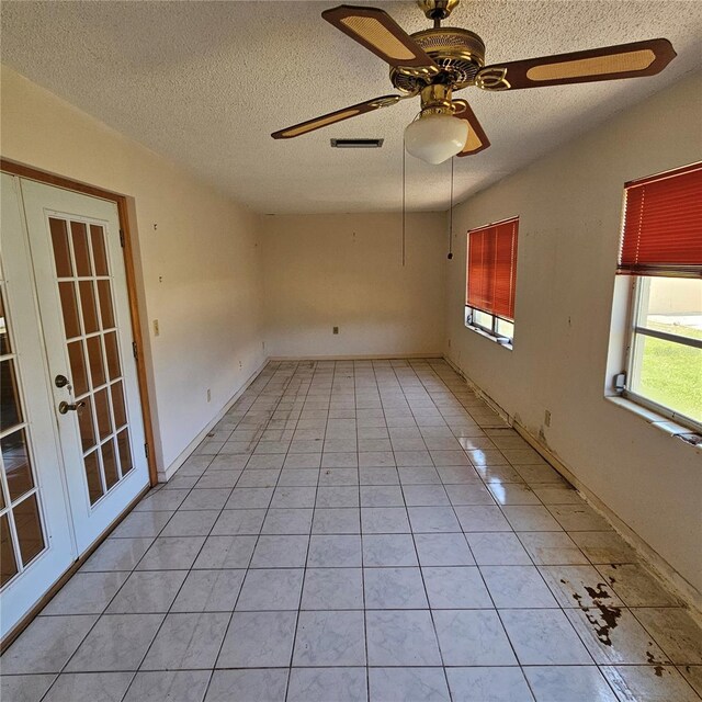 8635 SW 95th St Unit G, Ocala, FL 34481 - empty room featuring ceiling fan, a textured ceiling, light tile patterned flooring, and french doors