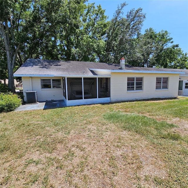 8635 SW 95th St Unit G, Ocala, FL 34481 - back of property with a sunroom, central AC unit, a lawn, and roof with shingles