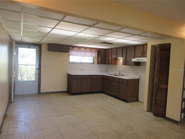 1675 SE 190th Ave, Silver Springs, FL 34488 - kitchen featuring under cabinet range hood, light countertops, baseboards, a paneled ceiling, and a sink