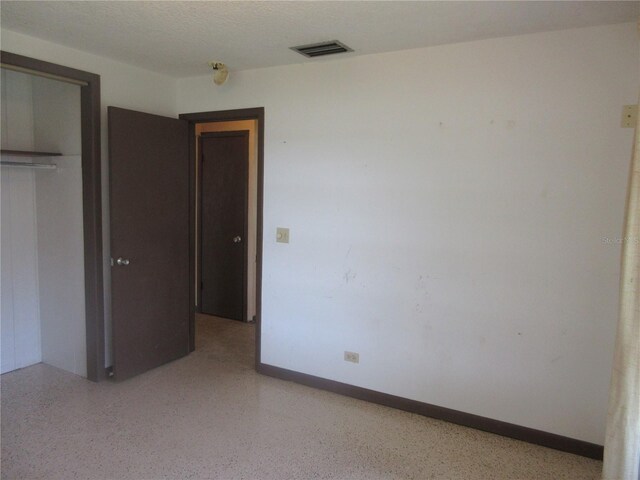 1675 SE 190th Ave, Silver Springs, FL 34488 - unfurnished bedroom featuring a closet, dark speckled floor, and baseboards