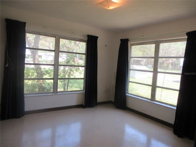 1675 SE 190th Ave, Silver Springs, FL 34488 - empty room with baseboards, healthy amount of natural light, and a textured ceiling