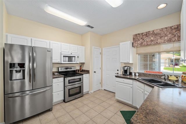 9408 SE 132nd Loop, Summerfield, FL 34491 - kitchen with appliances with stainless steel finishes, a sink, dark countertops, white cabinetry, and recessed lighting