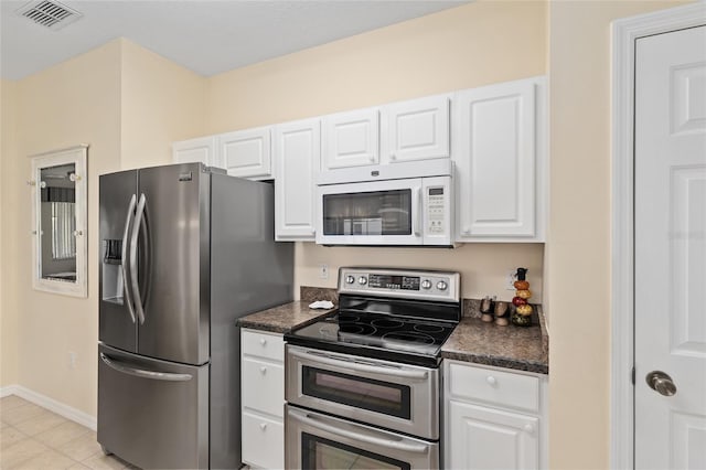 9408 SE 132nd Loop, Summerfield, FL 34491 - kitchen with appliances with stainless steel finishes, dark countertops, white cabinets, and baseboards