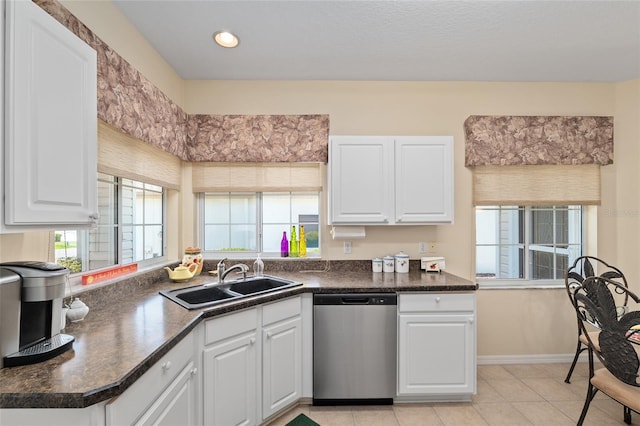 9408 SE 132nd Loop, Summerfield, FL 34491 - kitchen with stainless steel dishwasher, a sink, dark countertops, white cabinetry, and light tile patterned floors