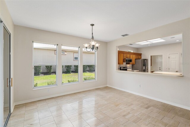 13495 SE 93rd Court Rd, Summerfield, FL 34491 - kitchen with appliances with stainless steel finishes, brown cabinets, a chandelier, pendant lighting, and baseboards
