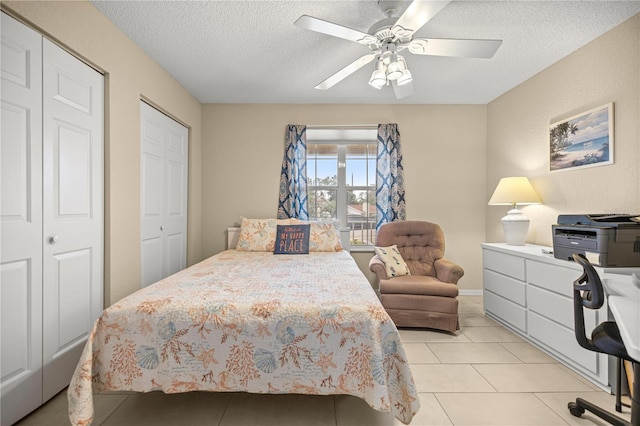 8137 SW 117th Loop, Ocala, FL 34481 - bedroom with a textured ceiling, light tile patterned flooring, a ceiling fan, and two closets