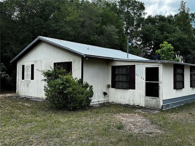 20704 SW Rainbow Lakes Blvd, Dunnellon, FL 34431 - view of home's exterior featuring metal roof and a lawn