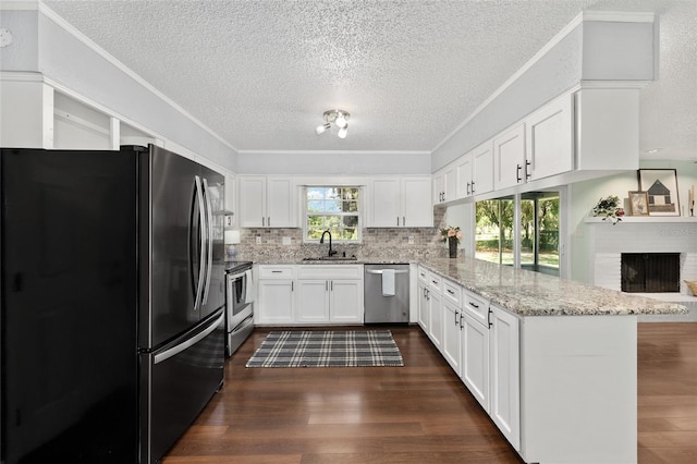 1812 SE 38th Ave, Ocala, FL 34471 - kitchen featuring appliances with stainless steel finishes, a peninsula, a textured ceiling, white cabinetry, and light stone counters