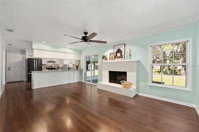 1812 SE 38th Ave, Ocala, FL 34471 - unfurnished living room with dark wood finished floors, a textured ceiling, a ceiling fan, a brick fireplace, and ornamental molding