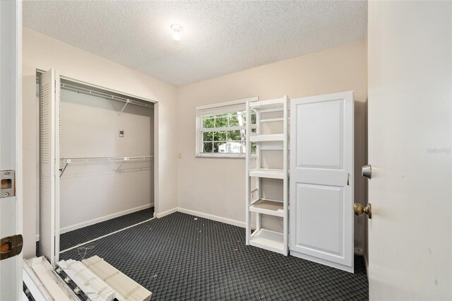 1812 SE 38th Ave, Ocala, FL 34471 - interior space featuring dark colored carpet, a textured ceiling, a closet, and baseboards