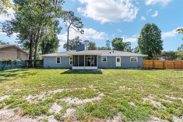 1812 SE 38th Ave, Ocala, FL 34471 - rear view of property featuring a sunroom, a chimney, and board and batten siding