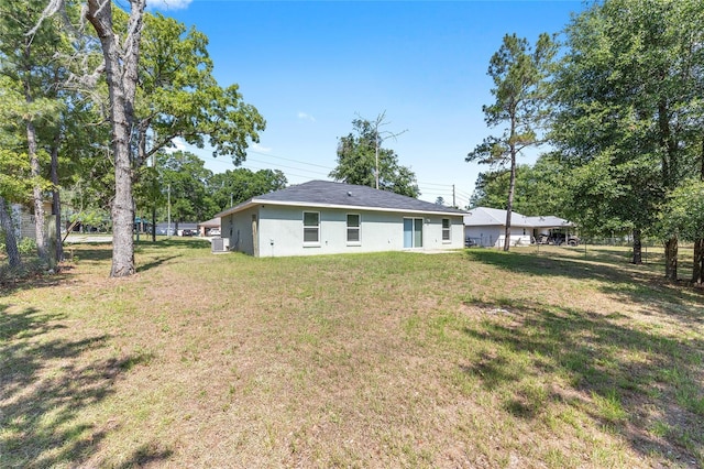 5425 Pecan Rd, Ocala, FL 34472 - back of property featuring a yard and stucco siding