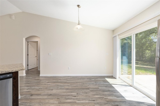 5425 Pecan Rd, Ocala, FL 34472 - unfurnished dining area featuring lofted ceiling, arched walkways, light wood finished floors, and baseboards