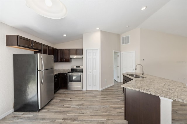 5425 Pecan Rd, Ocala, FL 34472 - kitchen with stainless steel appliances, a sink, vaulted ceiling, under cabinet range hood, and dark brown cabinetry