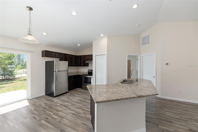 5425 Pecan Rd, Ocala, FL 34472 - kitchen with stainless steel appliances, vaulted ceiling, a sink, light wood-style floors, and baseboards