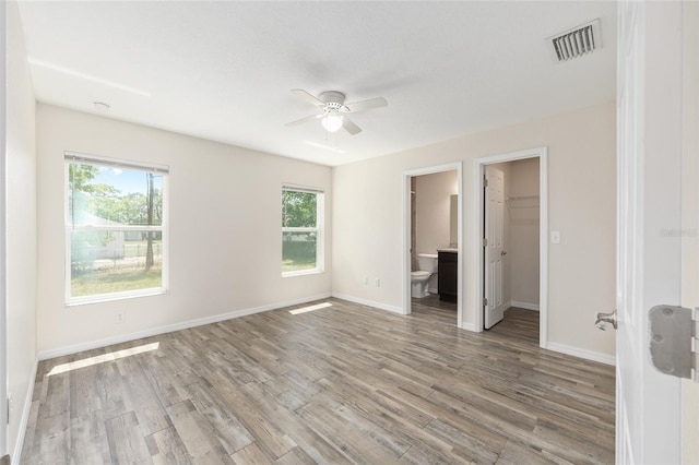 5425 Pecan Rd, Ocala, FL 34472 - unfurnished bedroom featuring light wood-style floors, multiple windows, baseboards, and a walk in closet