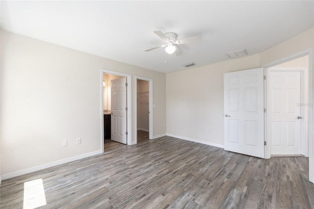 5425 Pecan Rd, Ocala, FL 34472 - unfurnished bedroom with wood finished floors, baseboards, a closet, and a spacious closet