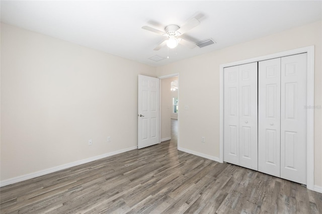 5425 Pecan Rd, Ocala, FL 34472 - unfurnished bedroom with wood finished floors, baseboards, a closet, and a ceiling fan