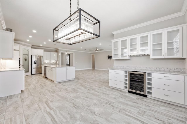 9777 SW 63rd Loop, Ocala, FL 34481 - kitchen with wine cooler, stainless steel appliances, ornamental molding, ceiling fan, and recessed lighting