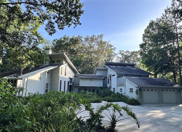 4305 SW 20th Ave, Ocala, FL 34471 - view of home's exterior with concrete driveway, a chimney, and an attached garage