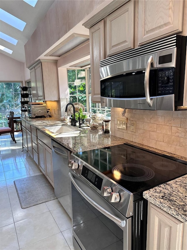 4305 SW 20th Ave, Ocala, FL 34471 - kitchen with stainless steel appliances, a skylight, a sink, tasteful backsplash, and lofted ceiling
