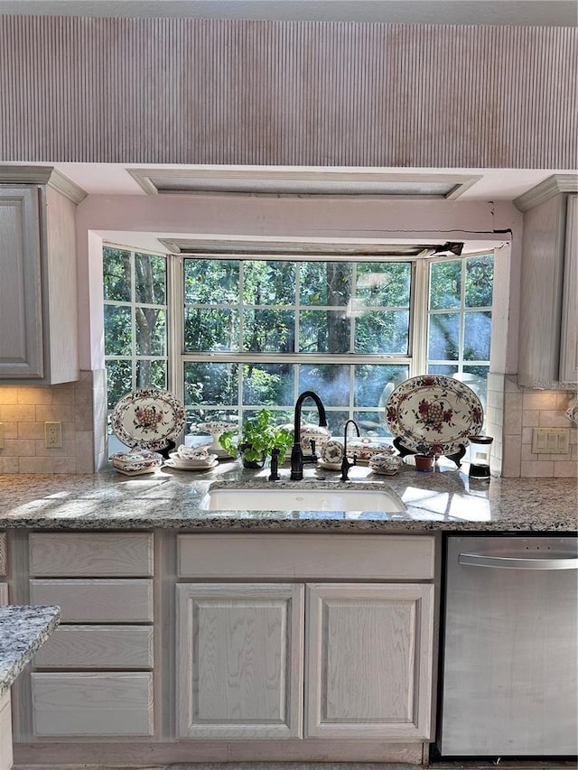 4305 SW 20th Ave, Ocala, FL 34471 - kitchen featuring stainless steel dishwasher, a sink, backsplash, and light stone countertops