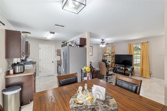2690 SW 154th Ln, Ocala, FL 34473 - dining room featuring light tile patterned flooring, a ceiling fan, a textured ceiling, and baseboards
