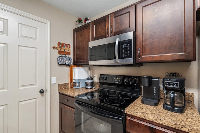 2690 SW 154th Ln, Ocala, FL 34473 - kitchen featuring black / electric stove, stainless steel microwave, dark brown cabinets, light stone countertops, and a textured ceiling