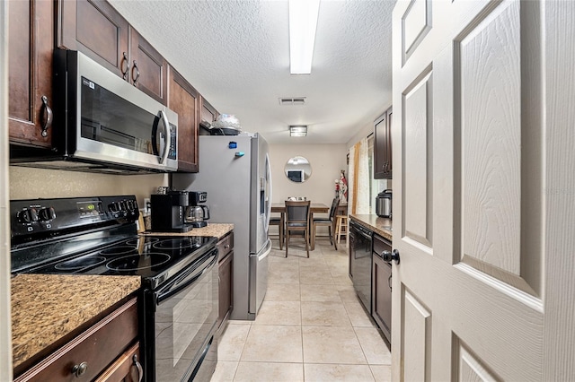 2690 SW 154th Ln, Ocala, FL 34473 - kitchen featuring black appliances, dark brown cabinets, light tile patterned floors, a textured ceiling, and light stone countertops