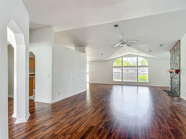 12352 SE 86th Ct, Belleview, FL 34420 - unfurnished living room with ceiling fan, dark wood-type flooring, lofted ceiling, baseboards, and a stone fireplace