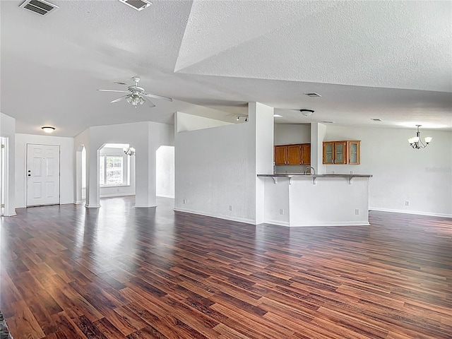 12352 SE 86th Ct, Belleview, FL 34420 - unfurnished living room featuring arched walkways, dark wood finished floors, a chandelier, ceiling fan, and a textured ceiling