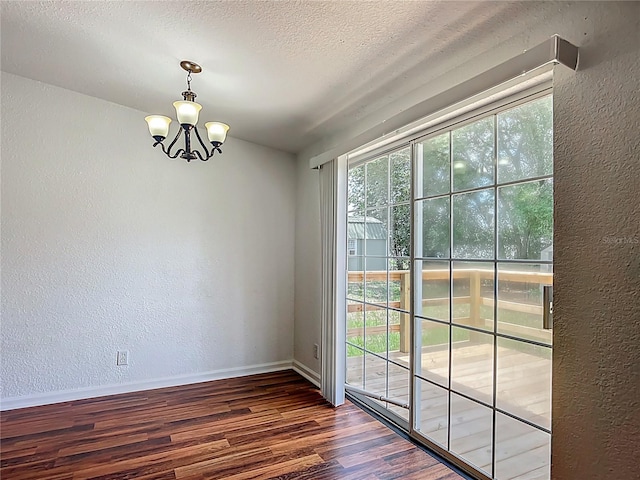 12352 SE 86th Ct, Belleview, FL 34420 - unfurnished dining area featuring a textured wall, wood finished floors, a chandelier, baseboards, and a textured ceiling