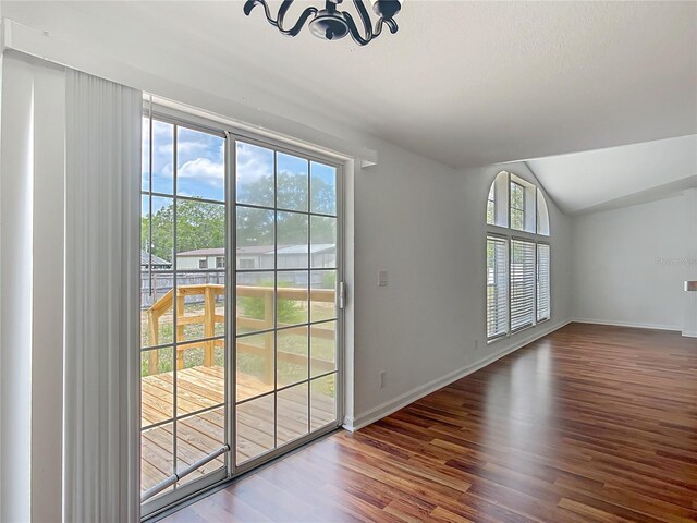 12352 SE 86th Ct, Belleview, FL 34420 - entryway with a chandelier, vaulted ceiling, wood finished floors, plenty of natural light, and baseboards