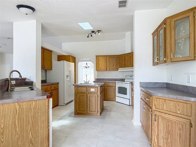 12352 SE 86th Ct, Belleview, FL 34420 - kitchen featuring white appliances, a sink, under cabinet range hood, and brown cabinets